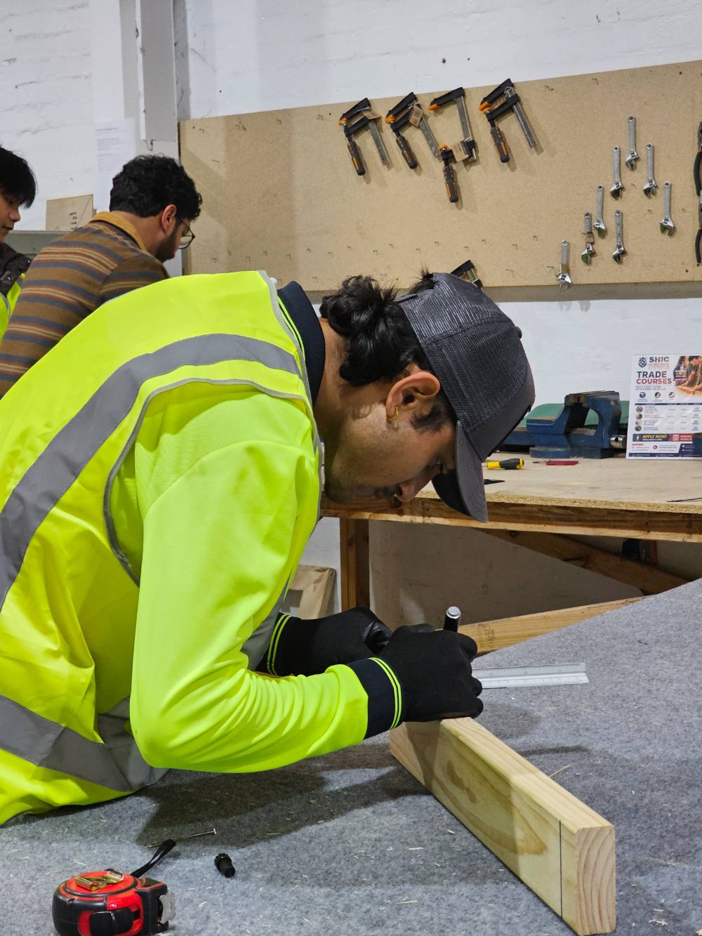 A student marking out a piece of timber at a workbench